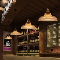 Rij van hanglampen met geribbeld glas boven een bar in een café met bakstenen muur 2