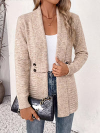 Model in beige vest met sjaalkraag, hand aan de rand, met zwarte krokodillenprint tas en spijkerbroek 3