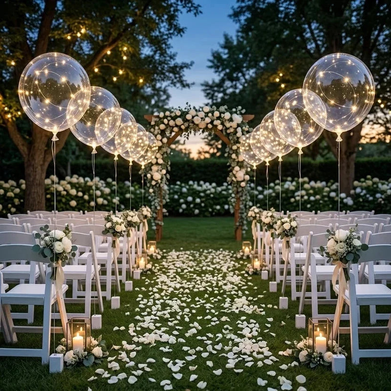 Lichtgevende ballonnen langs het looppad van een tuinbruiloft met witte stoelen, rozenblaadjes en bloemenboog 6