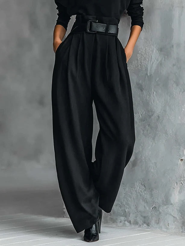 Detail van de zwarte broek met hoge taille, plooien en wijde pijpen, gedragen met riem 4