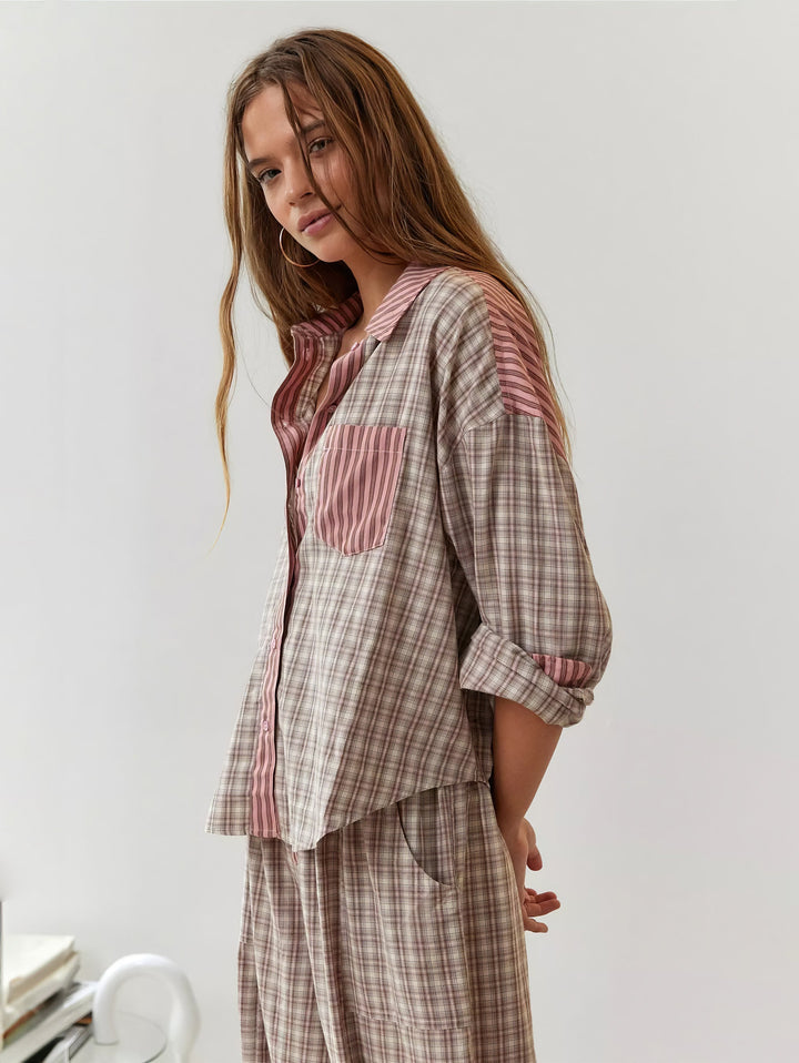 Model in beige roze geruite pyjamaset met roze gestreepte kraag en borstzak, schuin van opzij gefotografeerd met mouwen opgerold. 2