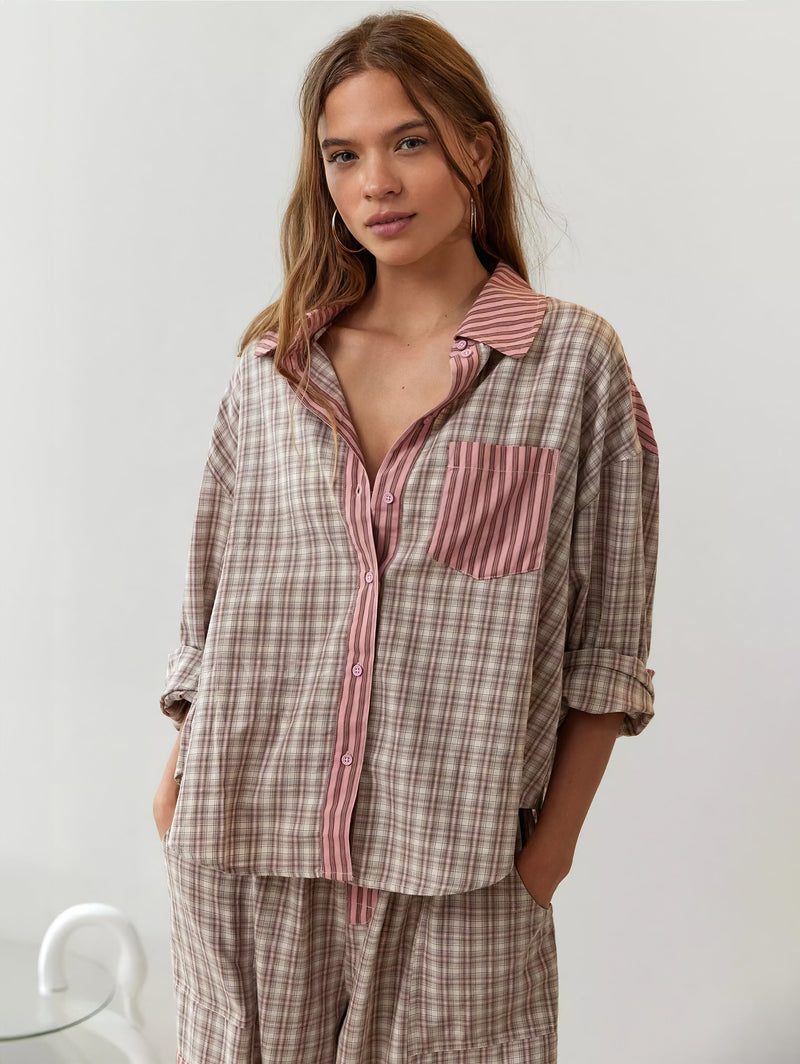 Voorkant van het beige roze geruite overhemd met roze gestreepte borstzak en knoopsluiting, model kijkt de camera in met handen in de zakken. 4