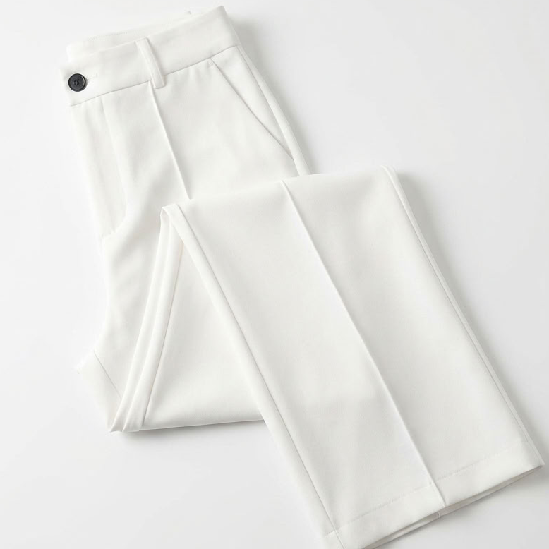 Opgevouwen witte broek op een lichte ondergrond met zwarte knoop en persplooi 7