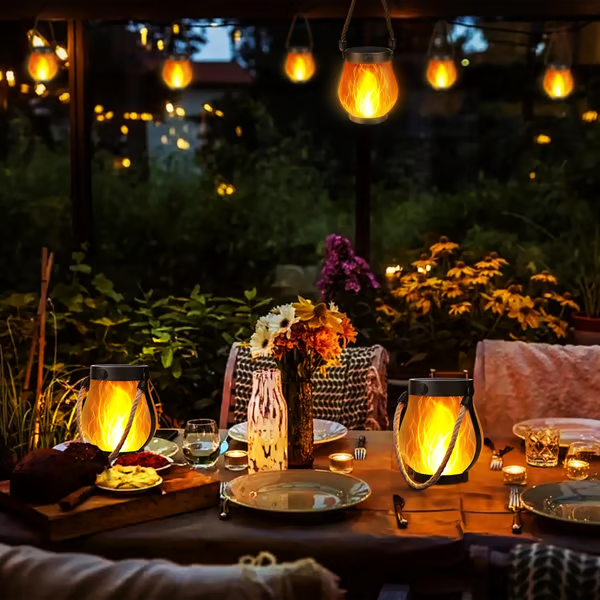 Gedekte tuintafel in de avond met twee gloeiende lantaarns en hangende lantaarns erboven 7