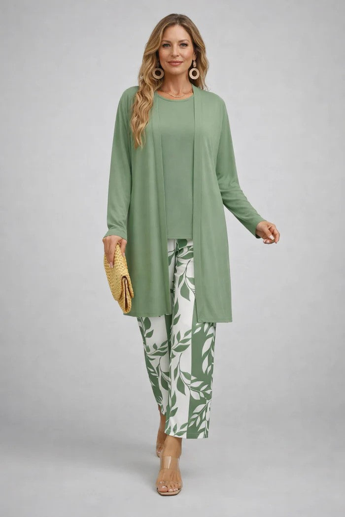 Model in lichtgroen vest en top met broek met groen-witte bladprint, gele clutch en doorzichtige sandalen. 10