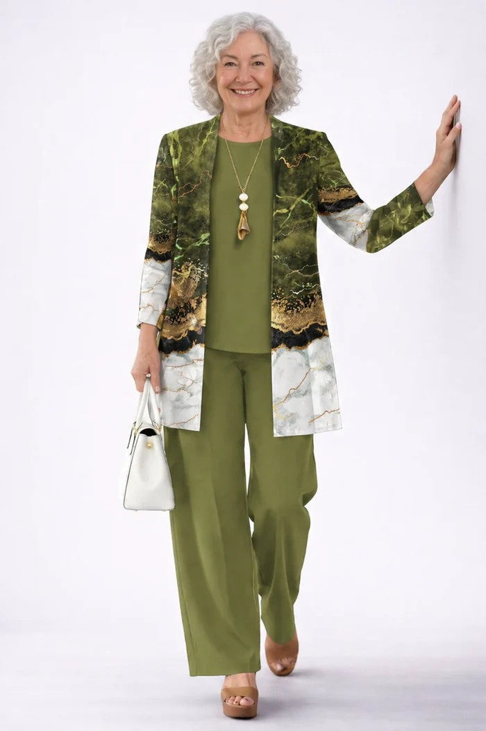 Oudere model met grijs krullend haar in groene set met open vest met marmerprint in groen, goud en wit. 19