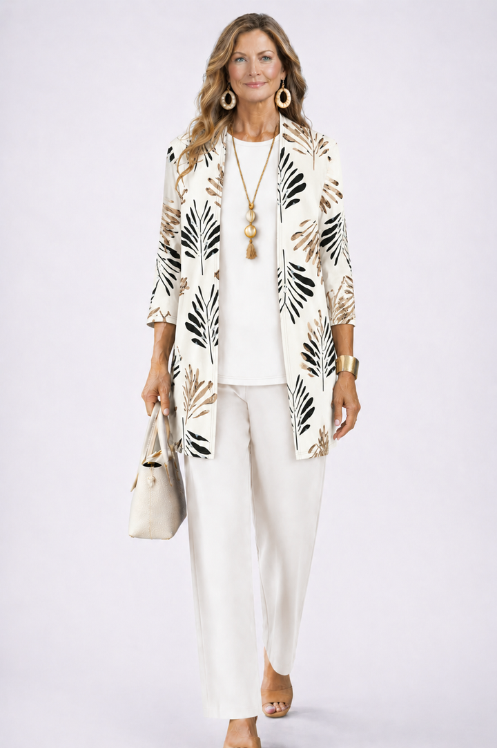 Model in witte set met zwarte en beige bladprint op het open vest, effen witte top en broek. 4
