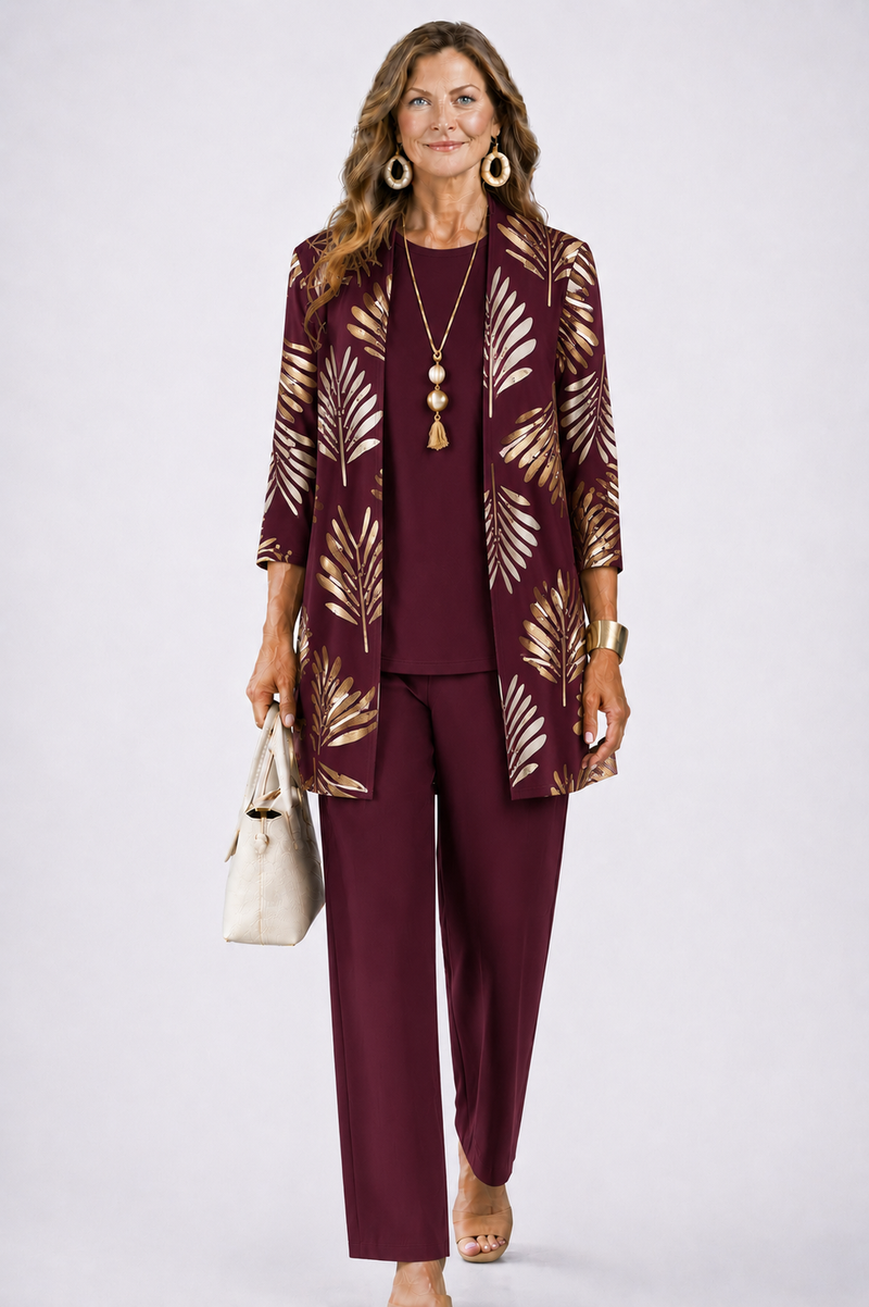 Model in bordeauxrode set met gouden bladprint op het open vest, effen top en rechte broek. 6