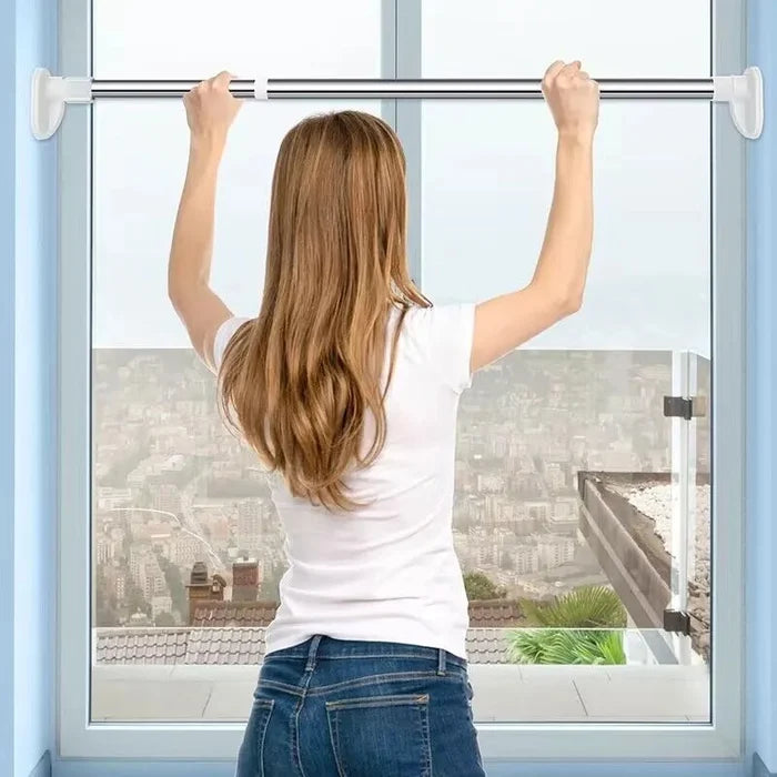 Vrouw van achteren hangt met beide handen aan de stang die tussen het kozijn van een raam geklemd zit. 3
