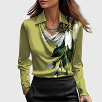 Model draagt de groene satijnen blouse met een grote witte bloemprint met bladeren op de borst, gecombineerd met een zwarte rok. 7
