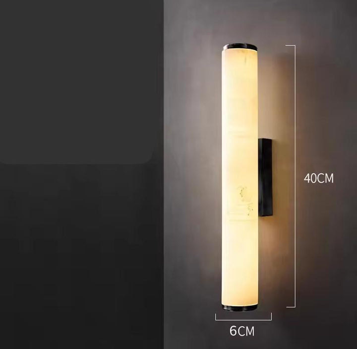 Verlichte cilindrische marmeren wandlamp tegen een donkere muur, met maataanduiding van 40 cm hoog en 6 cm breed. 22