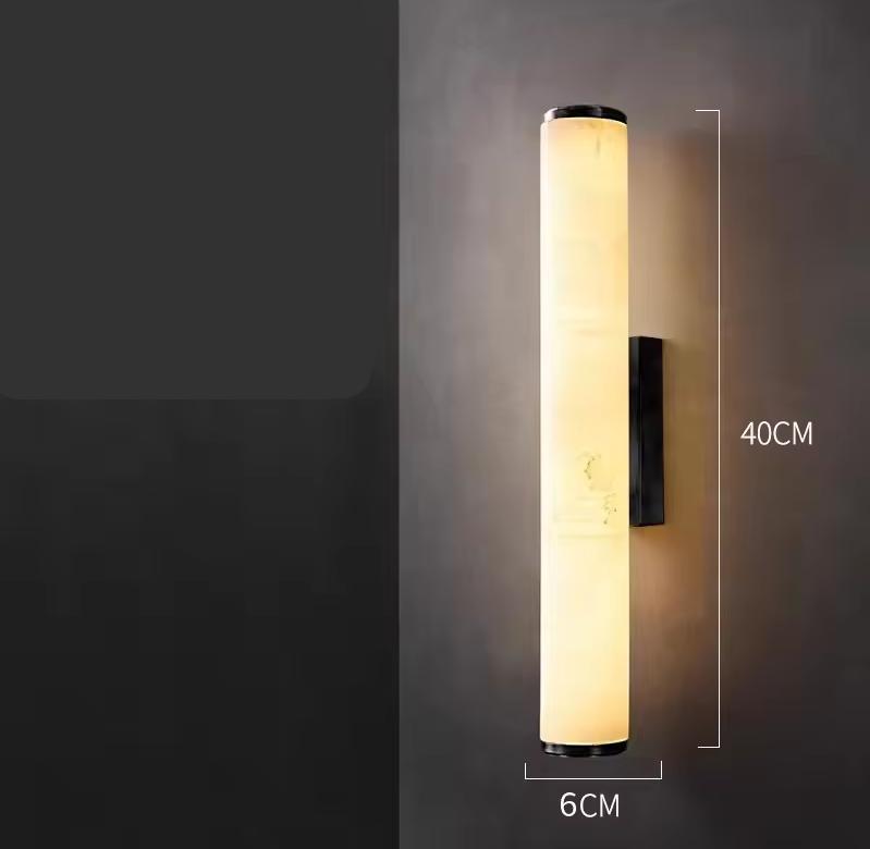 Verlichte cilindrische marmeren wandlamp tegen een donkere muur, met maataanduiding van 40 cm hoog en 6 cm breed. 22