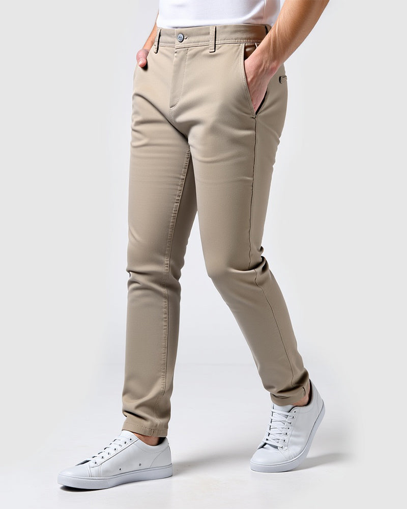Zandkleurige beige slim fit chino van opzij gedragen met wit shirt en witte sneakers, handen in de zakken. 14