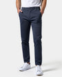 Donkerblauwe slim fit chino van voren gedragen met wit shirt en witte sneakers, beide handen in de zakken. 15