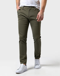 Olijfgroene slim fit chino van voren gedragen met wit shirt en witte sneakers, een hand in de zak. 13