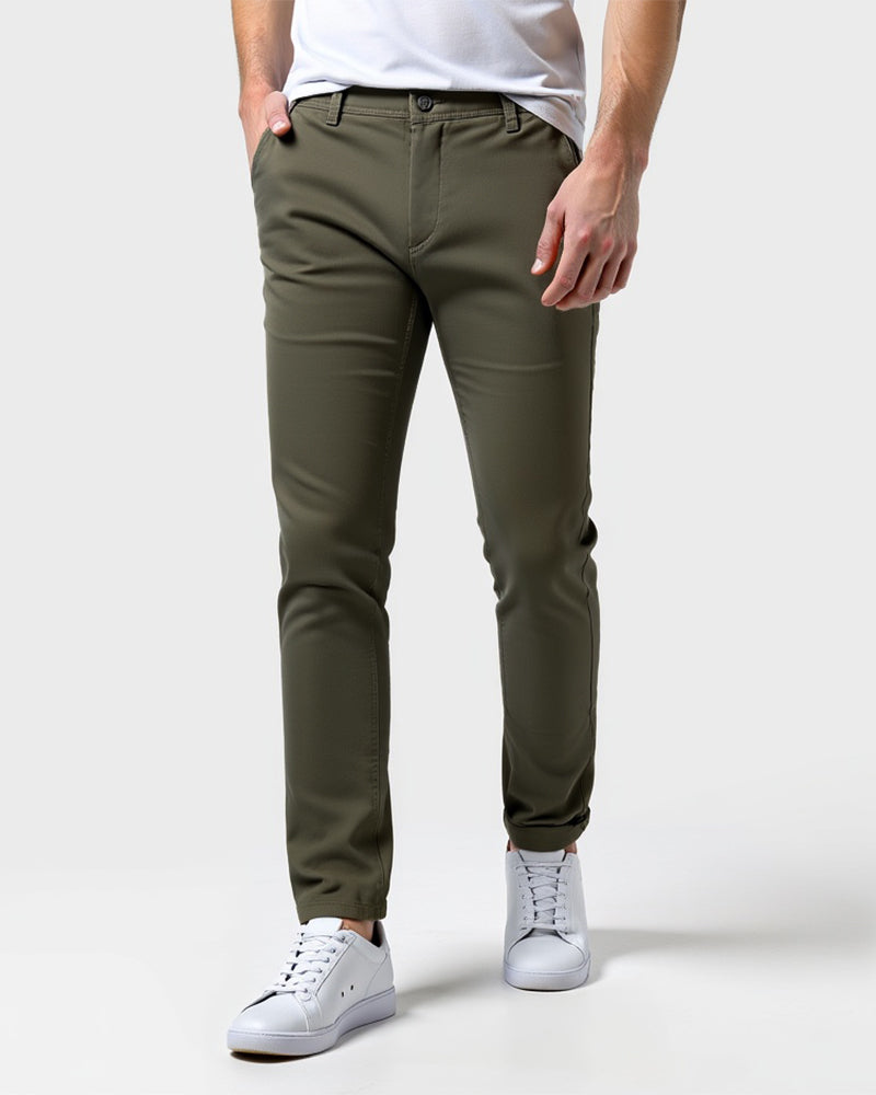 Olijfgroene slim fit chino van voren gedragen met wit shirt en witte sneakers, een hand in de zak. 13