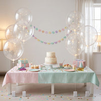 Lichtgevende ballonnen rond een verjaardagstafel met taart, cupcakes, cadeaus en pastelkleurige slingers 7