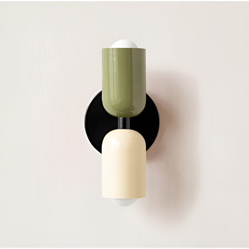 Wandlamp met groene bovenkap, crèmekleurige onderkap en ronde zwarte wandplaat tegen een lichte muur. 21