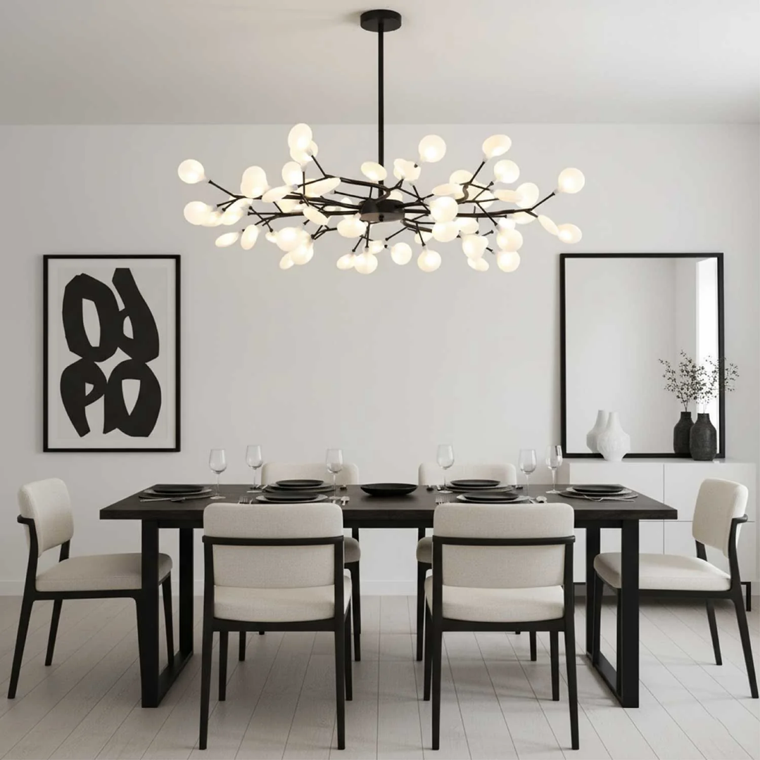 Zwarte takkenlamp boven een zwarte eettafel in een lichte, minimalistische eetkamer met grafisch schilderij 2