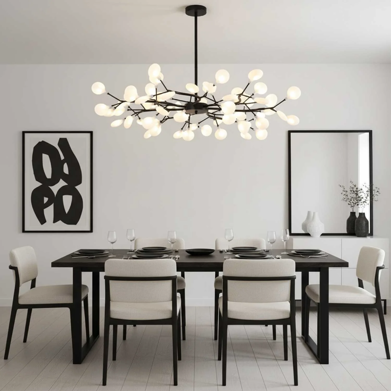 Zwarte takkenlamp boven een zwarte eettafel in een lichte, minimalistische eetkamer met grafisch schilderij 2