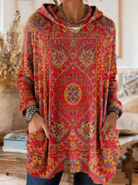 Rode tuniek met capuchon en gele en blauwe tapijtprint, close-up van de voorkant met grote opgestikte zakken. 4