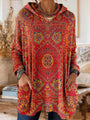 Rode tuniek met capuchon en gele en blauwe tapijtprint, close-up van de voorkant met grote opgestikte zakken. 4