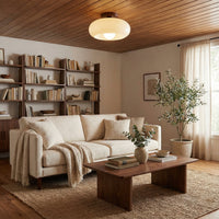 Lamp aan een houten plafond boven een crèmekleurige bank, salontafel en jutetapijt in een gezellige woonkamer 2