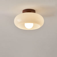 Brandende lamp met ronde glazen kap en zichtbare bol, vrijstaand tegen een lichte plafondachtergrond 6