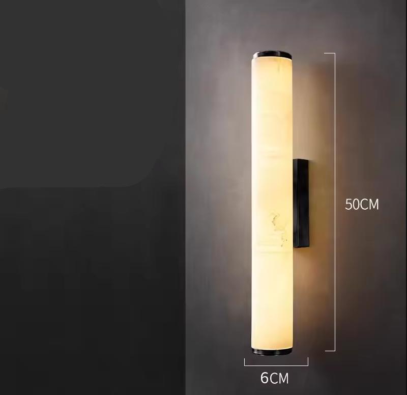 Verlichte cilindrische marmeren wandlamp tegen een donkere muur, met maataanduiding van 50 cm hoog en 6 cm breed. 21