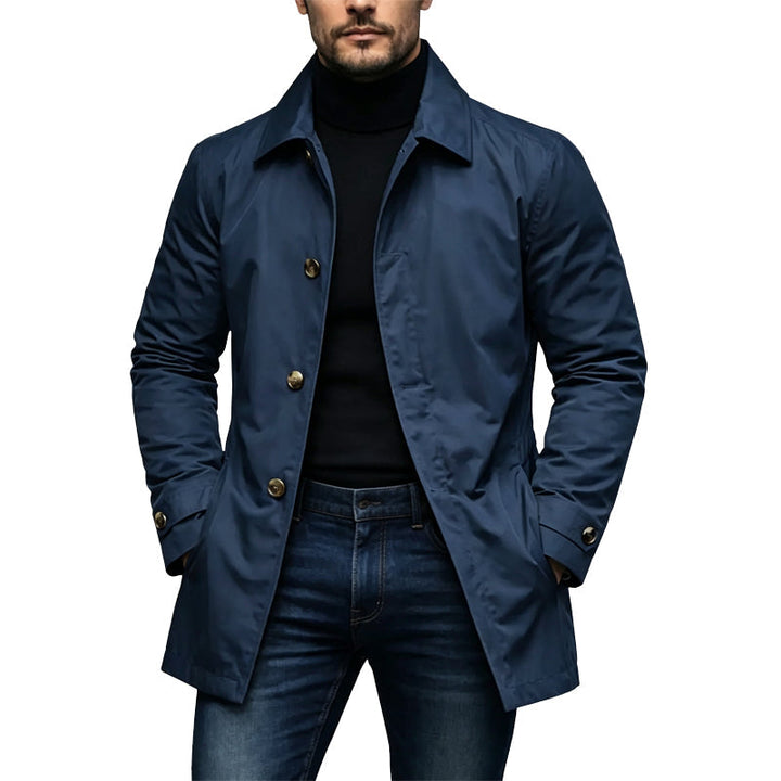 Trenchcoat in marineblauw met goudkleurige knopen, gedragen door een man met coltrui en jeans 4