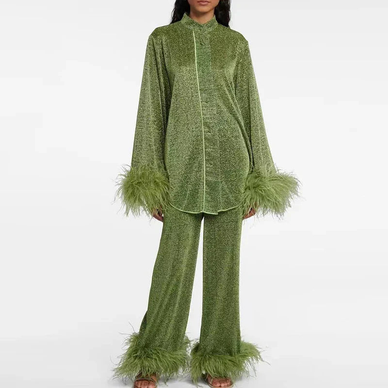 Model draagt de glitterset in mosgroen met lichte bies langs de knoopsluiting en groene veren aan de mouwen en broekspijpen. 4