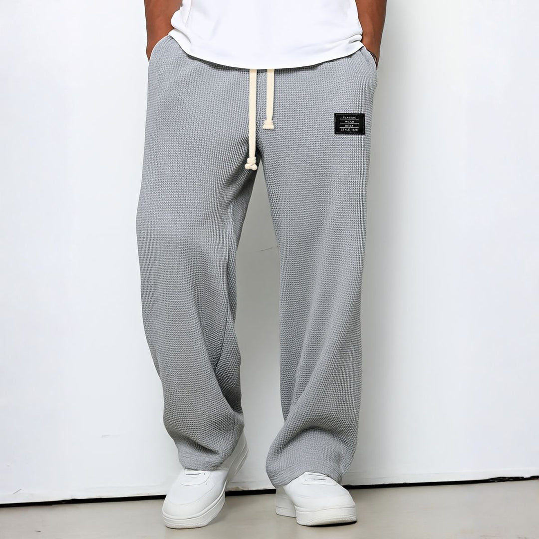 Model draagt de wafelstructuur broek in lichtgrijs met witte trekkoord en witte sneakers 6