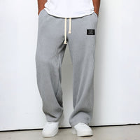 Model draagt de wafelstructuur broek in lichtgrijs met witte trekkoord en witte sneakers 6