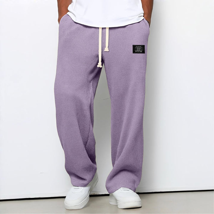 Model draagt de wafelstructuur broek in lila met witte trekkoord en witte sneakers 10