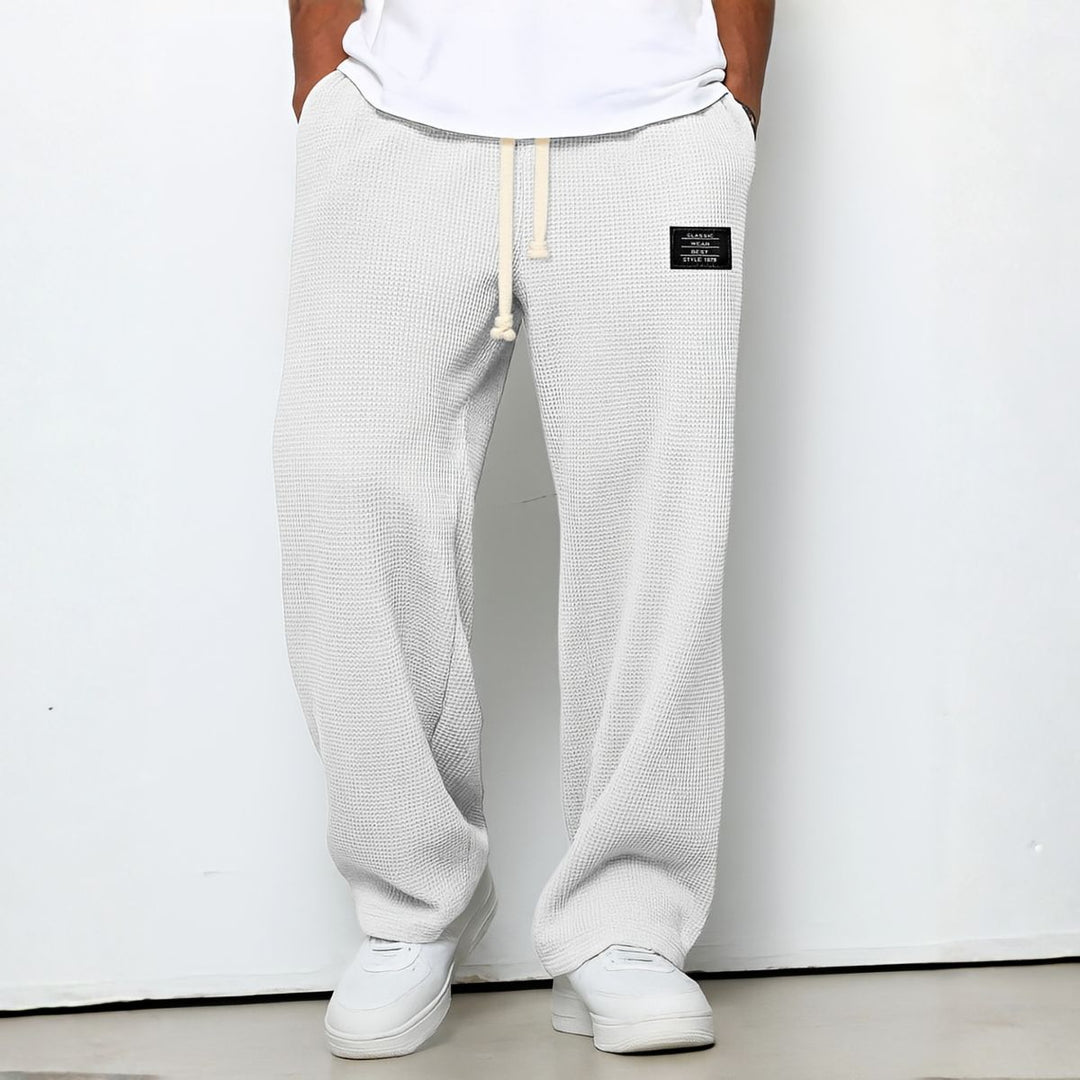 Model draagt de wafelstructuur broek in witte tint met trekkoord en witte sneakers 8