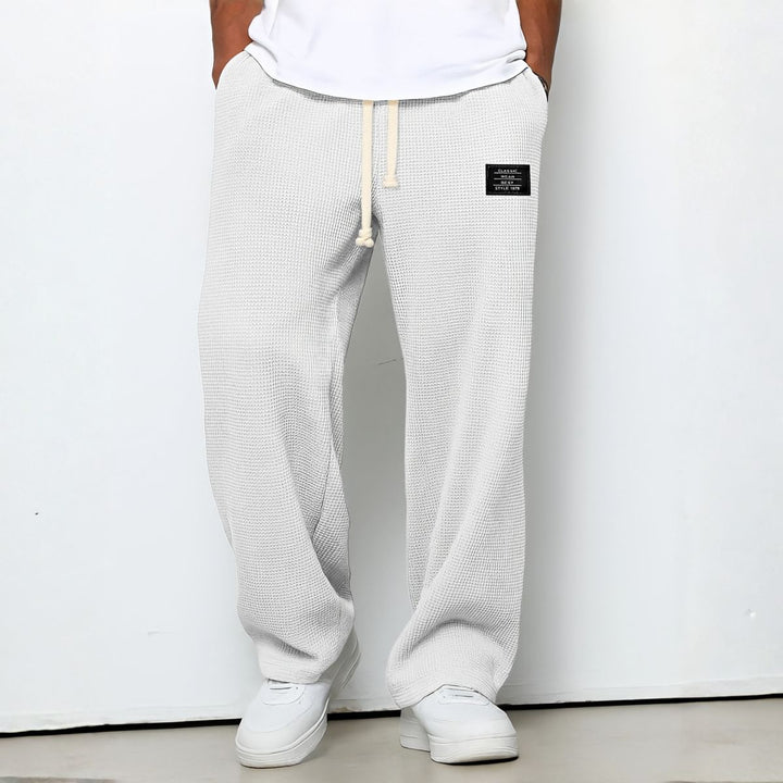 Model draagt de wafelstructuur broek in witte tint met trekkoord en witte sneakers 8