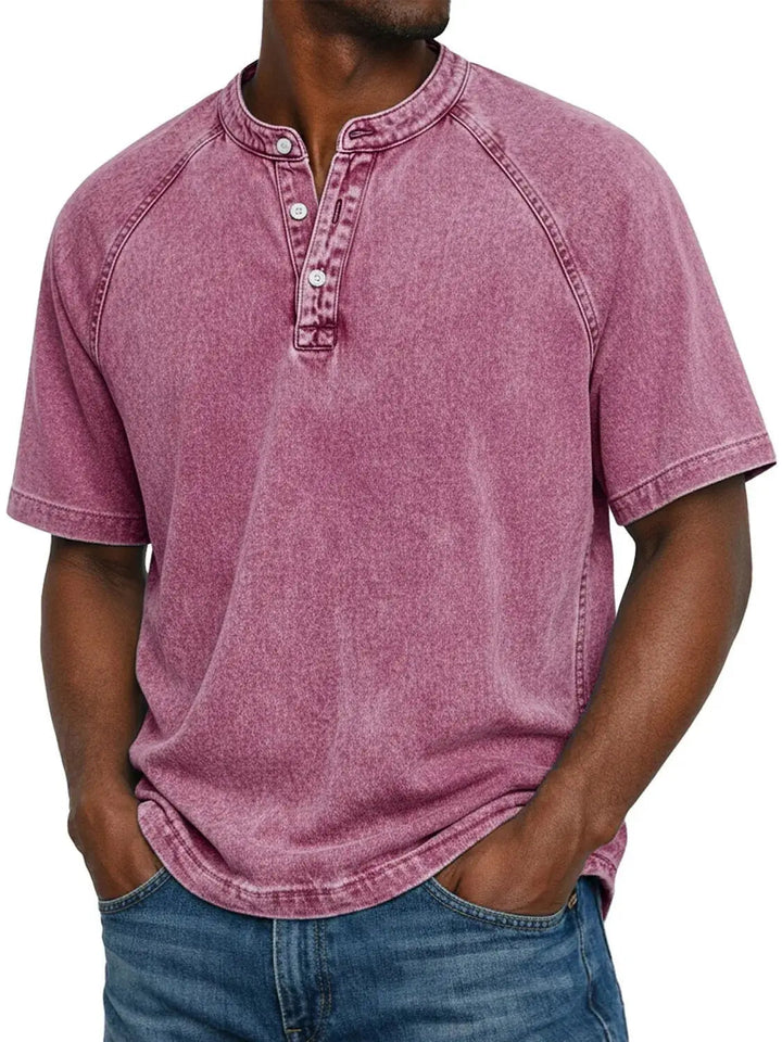 Model draagt het gewassen shirt met knoopsluiting en raglanmouwen in roze, gecombineerd met een spijkerbroek. 10