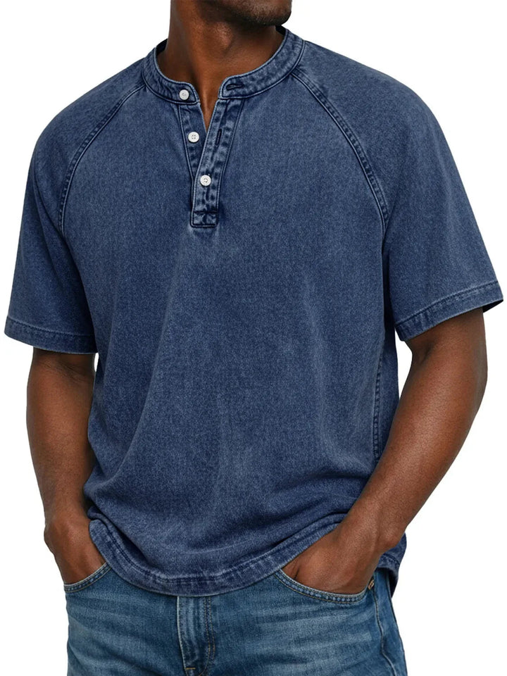 Model draagt het gewassen shirt met knoopsluiting en raglanmouwen in donkerblauw, gecombineerd met een spijkerbroek. 3