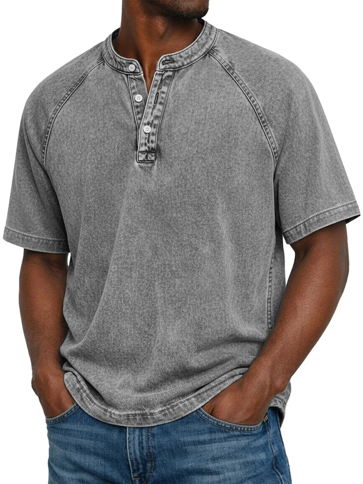 Model draagt het gewassen shirt met knoopsluiting en raglanmouwen in grijs, gecombineerd met een spijkerbroek. 4