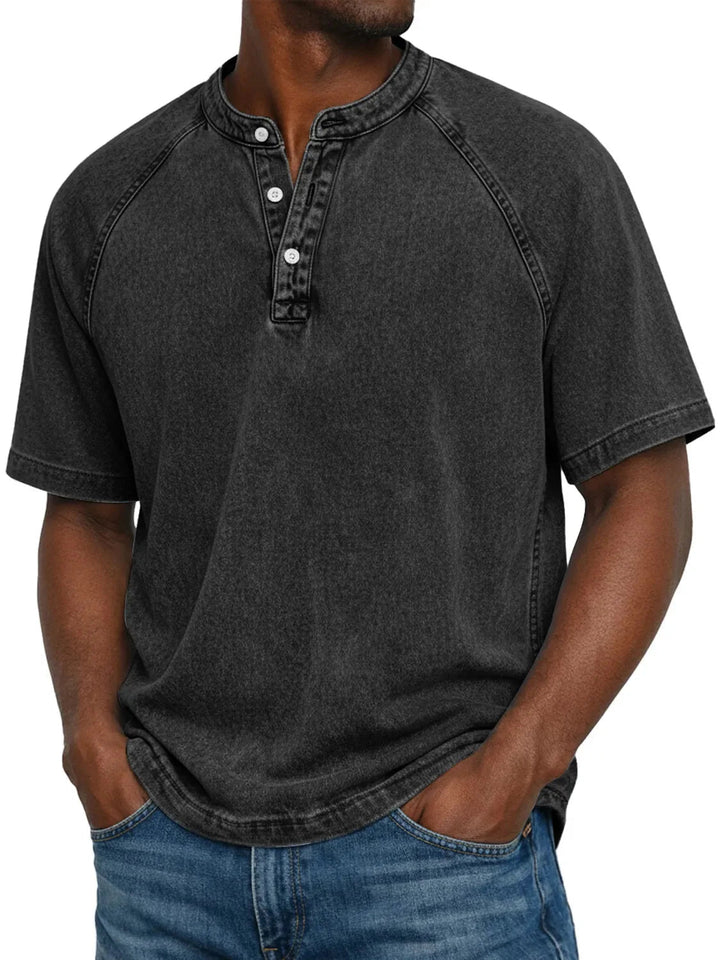 Model draagt het gewassen shirt met knoopsluiting en raglanmouwen in zwart, gecombineerd met een spijkerbroek. 5