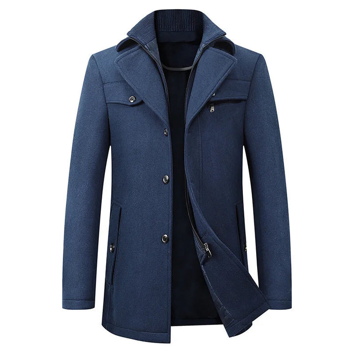 Voorkant van de peacoat in blauw, met geopende binnenlaag, rij knopen, borstzak met rits en een gebreide opstaande kraag. 3