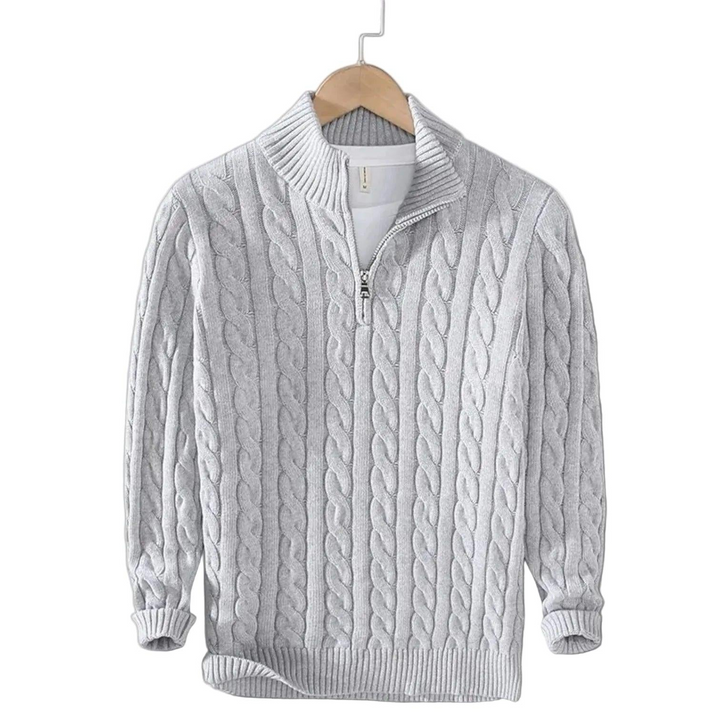 Lichtgrijze kabeltrui met opstaande kraag en korte rits aan een houten kleerhanger, met een wit shirt eronder. 4