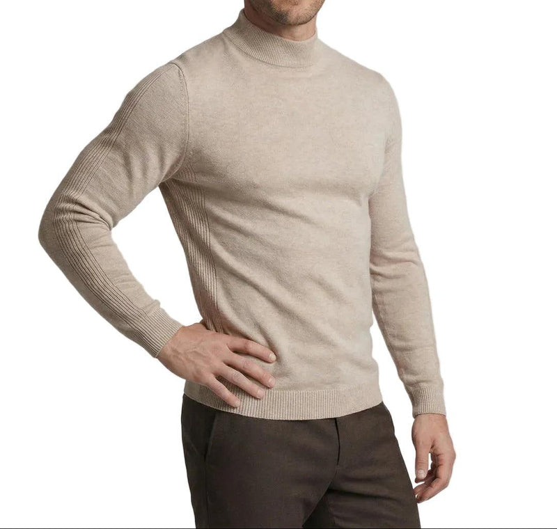 Model draagt de beige trui met opstaande kraag, een hand op de heup, schuin van voren 1