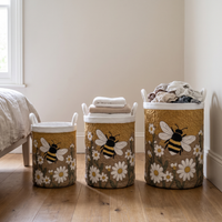 Drie manden in verschillende maten naast elkaar in een slaapkamer, gevuld met handdoeken en kleding. 4