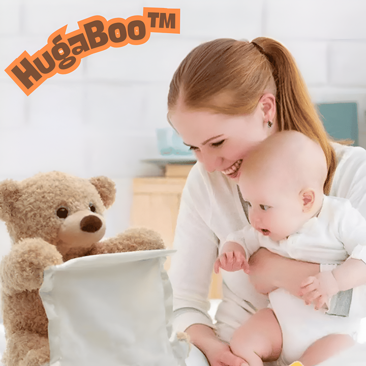 Lachende moeder met baby op schoot kijkt naar een pluchen beer die over een crèmekleurige doek heen gluurt. 6