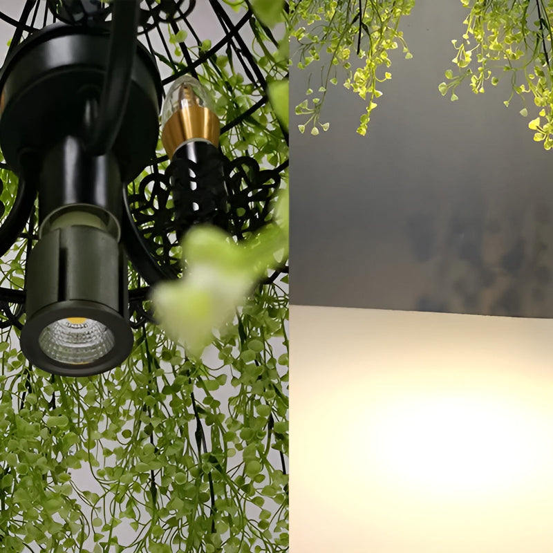 Close-up van het zwarte metalen frame met spotlamp en kaarslamp, omgeven door groene kunstranken, naast het warme lichteffect 9