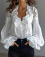 Witte blouse met kanten V-hals en ballonmouwen, handen in de zakken van een zwarte jeans 1