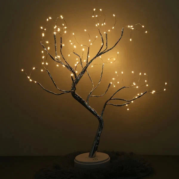 Boomlamp met gebogen takken en verspreide lichtjes tegen een donkere achtergrond, op een ronde witte voet 4