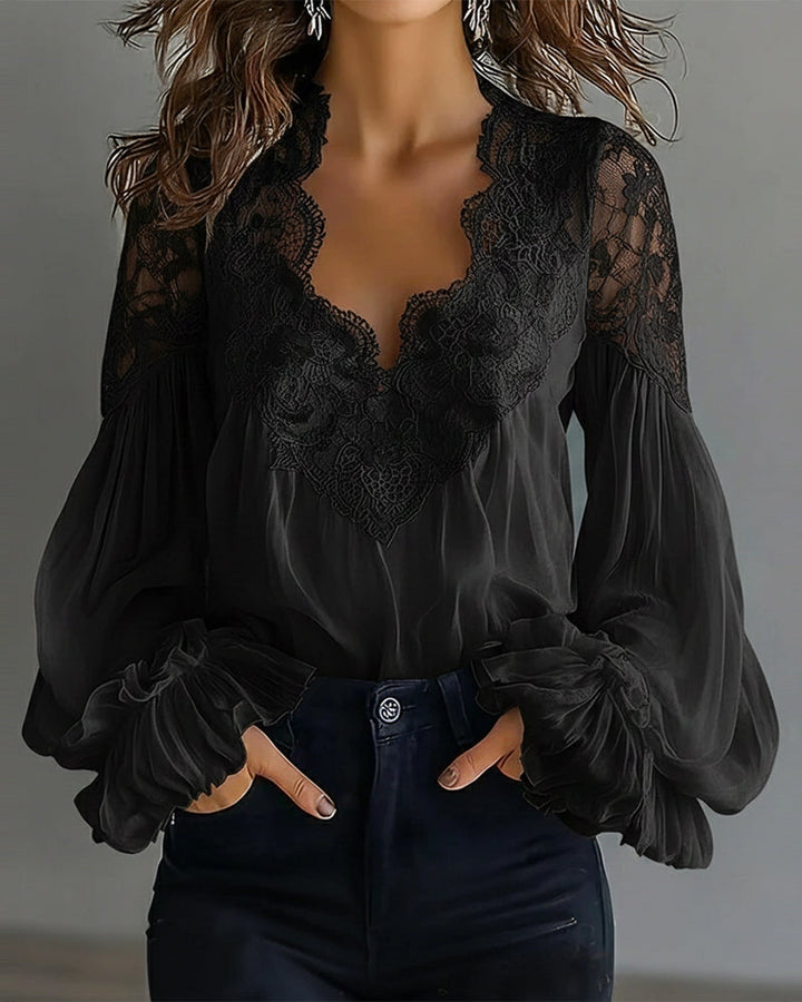 Zwarte blouse met kanten V-hals en ballonmouwen, handen in de zakken van een zwarte jeans 6