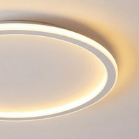 Close-up van een deel van de lichtring met de witte rand, die een warme gloed op het plafond werpt. 2